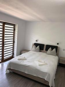 a bedroom with a large bed with two towels on it at Popasul de Sub Munte in Văleni +19 photos