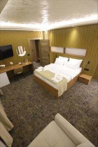 a bedroom with a bed and a desk and a television at Aqua Raj ND in Novi Pazar