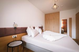 ein Schlafzimmer mit einem großen weißen Bett mit weißen Kissen in der Unterkunft dolomites view apartment in Oberrasen