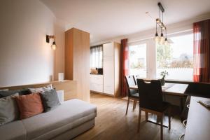 ein Wohnzimmer mit Couch und ein Esszimmer in der Unterkunft dolomites view apartment in Oberrasen
