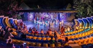 a group of people sitting in an auditorium watching a performance at Serenis Hotel in Side