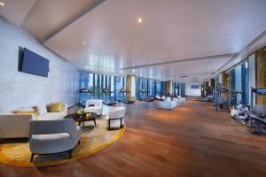 a large room with a gym with chairs and tables at New Century Grand Hotel Zunyi in Zunyi