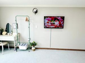 a room with a white wall with a tv on it at 유니크 in Busan