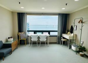 a living room with a table and a view of the ocean at 유니크 in Busan