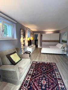 ein Schlafzimmer mit einem Bett, einem Sofa und einem Teppich in der Unterkunft Independent Room in Villa with Pool in Costermano sul garda