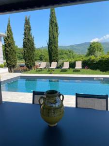 eine Vase auf einem Tisch vor einem Pool in der Unterkunft Independent Room in Villa with Pool in Costermano sul garda + 6 Fotos