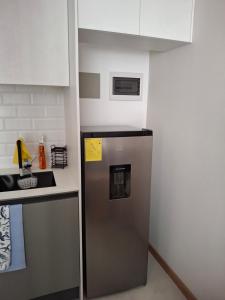 La cuisine est équipée d'un réfrigérateur en acier inoxydable. dans l'établissement Oma Deluxe, à Hacienda Carolina
