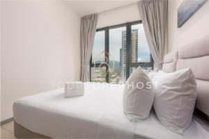 ein Schlafzimmer mit einem weißen Bett und einem großen Fenster in der Unterkunft 22 Macalisterz by YourSuperhost in George Town
