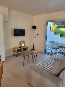 ein Wohnzimmer mit Sofa und Fernseher in der Unterkunft La Cabanne, 4 people, Royan center, 50 m beach, air conditioning in Royan + 9 Fotos