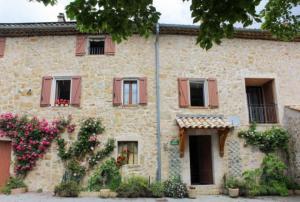 ein altes Steinhaus mit Blumen davor in der Unterkunft La bastide des moines in Peyroules