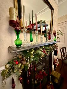 Eine Gruppe grüner Vasen auf einem Regal mit einem Weihnachtsbaum in der Unterkunft The Angove - Adults Only in Weymouth