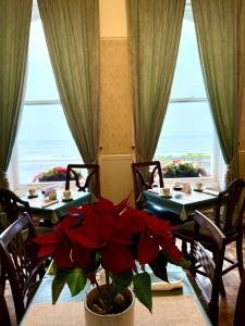 ein Esszimmer mit 2 Tischen und einem großen Fenster in der Unterkunft The Angove - Adults Only in Weymouth