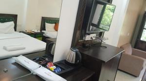 a room with a bed and a desk with a mirror at Kempty Lake Waterfall Resort - Run by Anaysha Group in Mussoorie