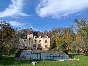 an old house with a greenhouse in front of it at Château de Villechauvon in Vatan