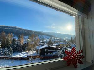 ein Fenster mit Blick auf eine schneebedeckte Stadt in der Unterkunft EveRest Apartamenty Szczyrk in Szczyrk