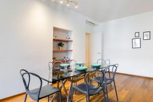 ein Esszimmer mit Glastisch und Stühlen in der Unterkunft Hostdomus - Lagrange Luxury Apartment in Turin