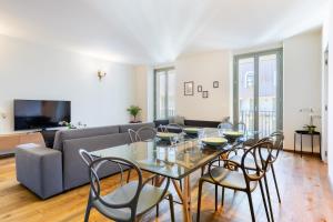 ein Wohnzimmer mit Tisch und Stühlen und einer Couch in der Unterkunft Hostdomus - Lagrange Luxury Apartment in Turin