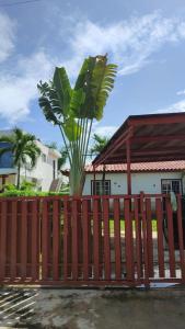 a palm tree on top of a wooden fence at Unique and quiet TROPICKÝ PRÁZDNINOVÝ DŮM in Punta Cana