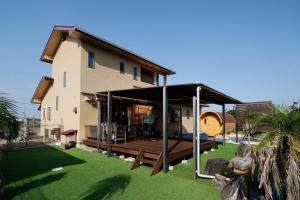 a house with a covered porch and a yard at 糸島リトリートヴィラ芥屋 in Itoshima