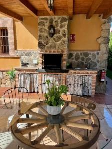 d'une terrasse avec une table et une cheminée en pierre. dans l'établissement La Casita de La Aduana, à Candeleda