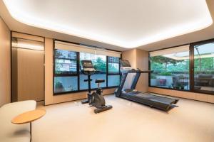 ein Raum mit einem Fitnessstudio mit Laufband und Fenstern in der Unterkunft All Seasons Hotel Guangzhou Wuyangcun Metro Station in Guangzhou
