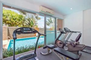 einen Fitnessraum mit zwei Heimtrainern und einem Pool in der Unterkunft Chic B309 in Ban Nong Chaeng