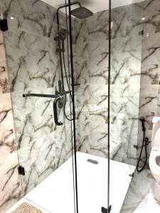 a bathroom with a glass shower with a toilet at Luxe Apartments Surulere in Lagos +36 photos