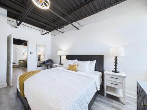 une chambre avec un grand lit blanc et un bureau dans l'établissement Modern Loft W Launch Views Near Beach -unit 208, à Cap Carnaveral