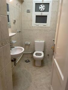 ein Badezimmer mit Toilette und Waschbecken und einem Fenster in der Unterkunft El Rehab city in New cairo + 12 Fotos