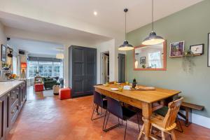 eine Küche und ein Esszimmer mit einem Holztisch und Stühlen in der Unterkunft Tiger Hall in Church Stretton