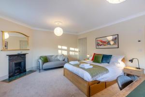 ein Schlafzimmer mit einem Bett und einer Couch und einem Kamin in der Unterkunft Tiger Hall in Church Stretton