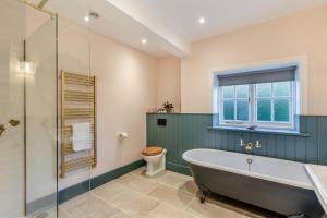 ein Badezimmer mit Badewanne und Toilette und einem Fenster in der Unterkunft Tiger Hall in Church Stretton + 39 Fotos