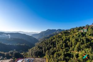 a view of a valley with trees and mountains at Zostel Homes Shoghi, Shimla in Shogi