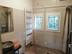 a bathroom with a shower and two windows at Moulin les Forges gîte 12 places avec piscine chauffée en Périgord in Gavaudun +6 photos