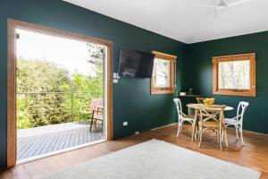 uma sala de jantar com uma mesa e uma varanda em Central studio with spabath em Daylesford