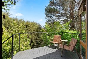 duas cadeiras e uma mesa em um deck de madeira em Central studio with spabath em Daylesford