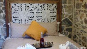 Bett mit einem Kopfteil aus Holz und einem Tablett darauf in der Unterkunft STONE of KAMARIZA in Áyios Konstandínos