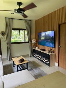 a living room with a couch and a flat screen tv at Zout Villas in Thong Sala