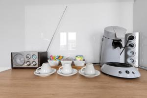 Eine Küche mit Kaffeemaschine und Geschirr auf der Arbeitsfläche. in der Unterkunft Cosy in Paris in Vanves