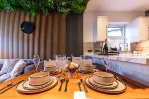 a dining room table with plates and wine glasses at Open Mind Property - 4 BR, Hot Tub & Free Parking in Portsmouth +54 photos