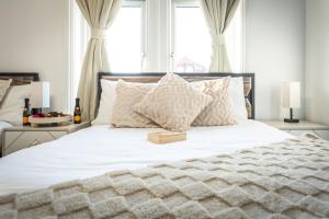 a bedroom with a white bed with a book on it at Open Mind Property - 4 BR, Hot Tub & Free Parking in Portsmouth