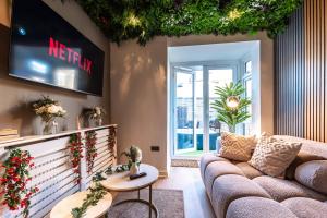 a living room with a couch and a tv at Open Mind Property - 4 BR, Hot Tub & Free Parking in Portsmouth