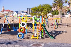 ein Spielplatz mit bunten Spielgeräten an einem Strand in der Unterkunft Waterfront Apartment in Lüderitz