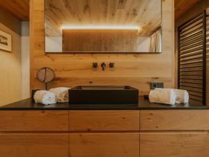 a bathroom with a counter with a sink and a mirror at Almrausch Lech Apartments in Lech am Arlberg +47 photos