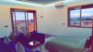 une chambre avec un lit, un canapé et des fenêtres dans l'établissement Suite nature montagne et petit déjeuner Villa Fatima, à Fès