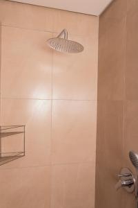 ein Bad mit einer Dusche mit einem Licht an der Wand in der Unterkunft Waterfront Apartment in Lüderitz