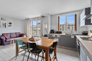 eine Küche und ein Wohnzimmer mit einem Holztisch und Stühlen in der Unterkunft Cosy in Paris in Vanves