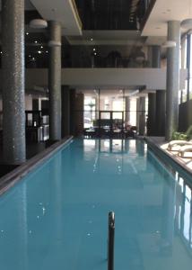 une grande piscine avec de l'eau bleue dans un immeuble dans l'établissement Umhlanga Apart Hotel, à Durban