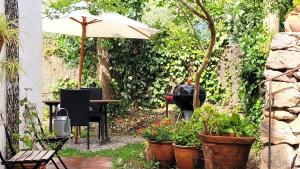 a garden with a grill and some plants and an umbrella at Tropical Studio in Órgiva