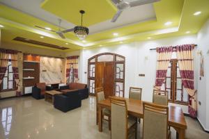 a living room with a table and a couch at Palm Villas Jaffna in Jaffna +22 photos